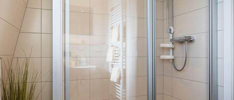 Chuveiro, toalhas de banho, sabonete