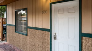 A building with a white door, a window, and the number 601 on the wall. - Cozy Condo, 1 Min to Yellowstone! Alpine #2 (West Yellowstone)