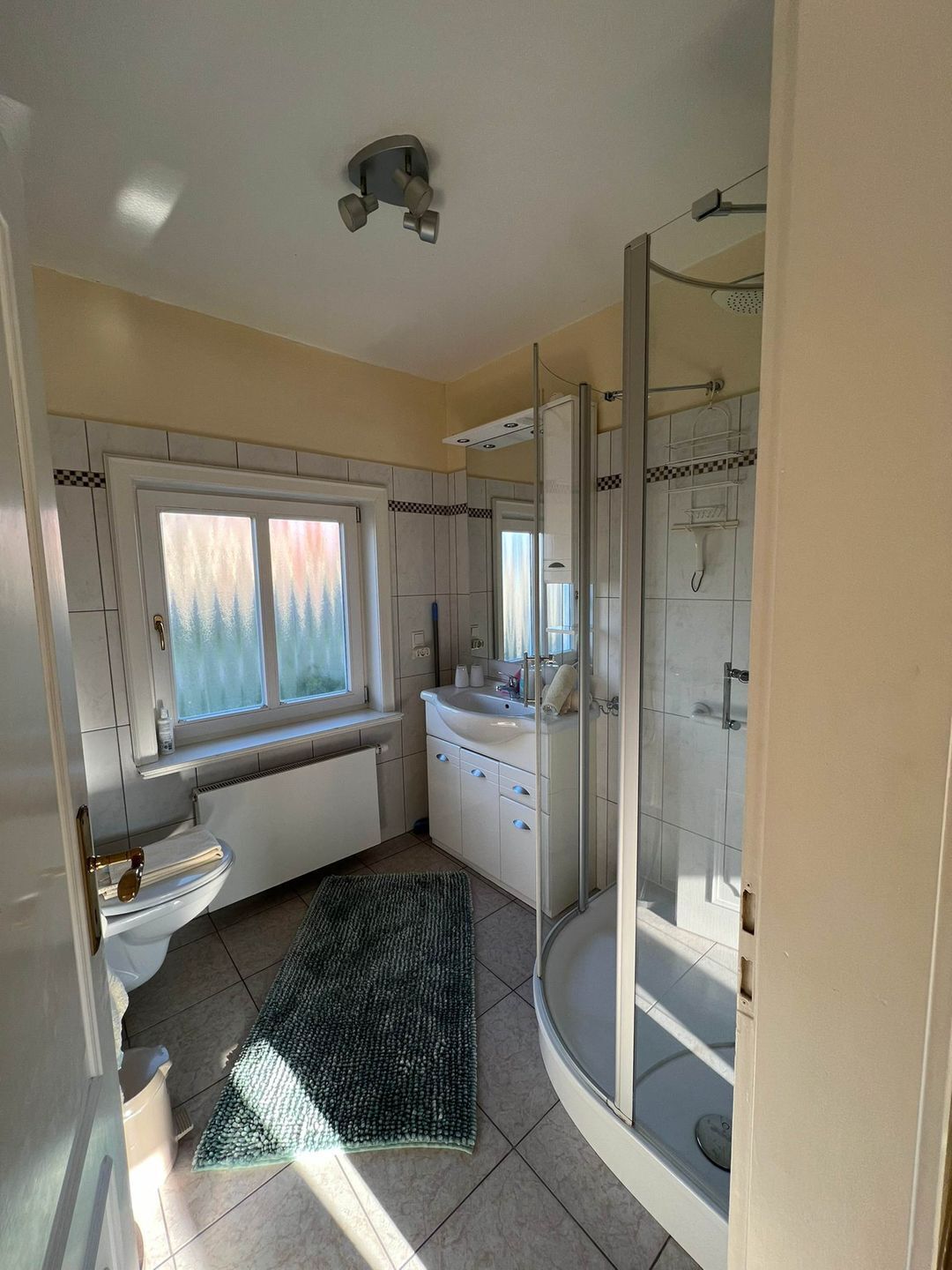 Ein modernes Badezimmer mit Toilette, Waschbecken und Dusche.
