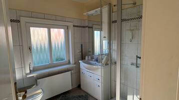 Ein modernes Badezimmer mit Toilette, Waschbecken und Dusche.