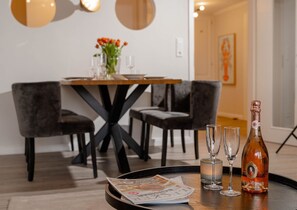 Une table à manger avec une bouteille de vin, deux verres et un plateau contenant un menu et des billets de banque.