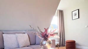 Un salon moderne avec un canapé, une table basse ronde et un vase décoratif.