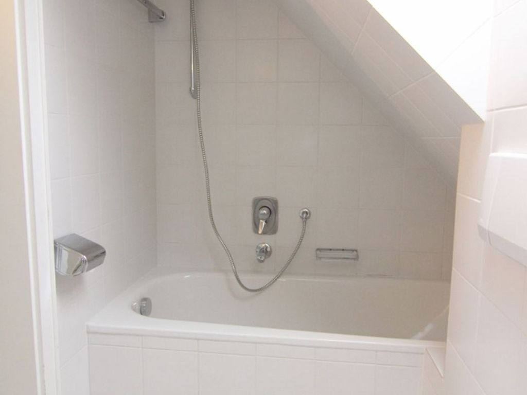 Une salle de bain avec une baignoire, une douche et des toilettes.