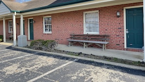 A brick building with a green door, a bench outside, and a satellite dish on the roof. - Rips Country Inn (Bowie)
