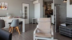 Een moderne woonkamer met een eethoek, een keuken en een trap.