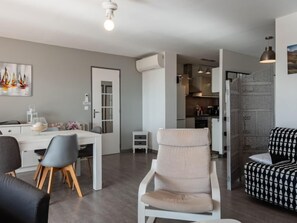 Una sala de estar moderna con comedor, cocina y escalera.