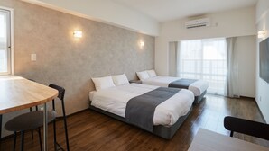 A modern hotel room with two beds, a wooden table, and a chair. - New Normal Hotel in NAMINOUE (Naha)