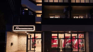 The exterior of the New Normal Hotel in Nammoe, featuring a modern design with large glass windows and a prominent entrance. - New Normal Hotel in NAMINOUE (Naha)