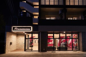 Exterior do Hotel New Normal em Nammoe, com design moderno, grandes janelas de vidro e entrada imponente.