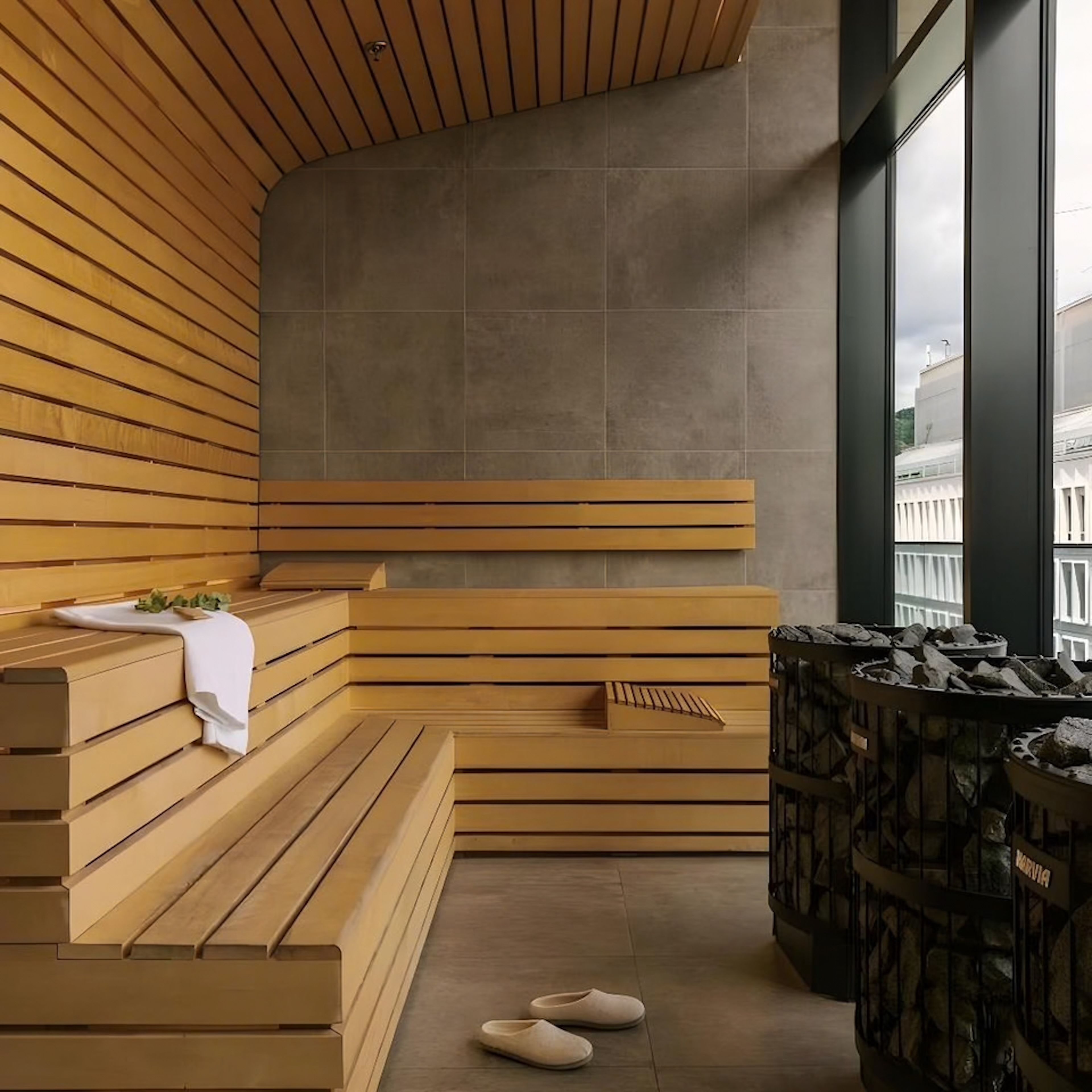 Un sauna con bancos de madera, un banco con una toalla y un banco de piedra.