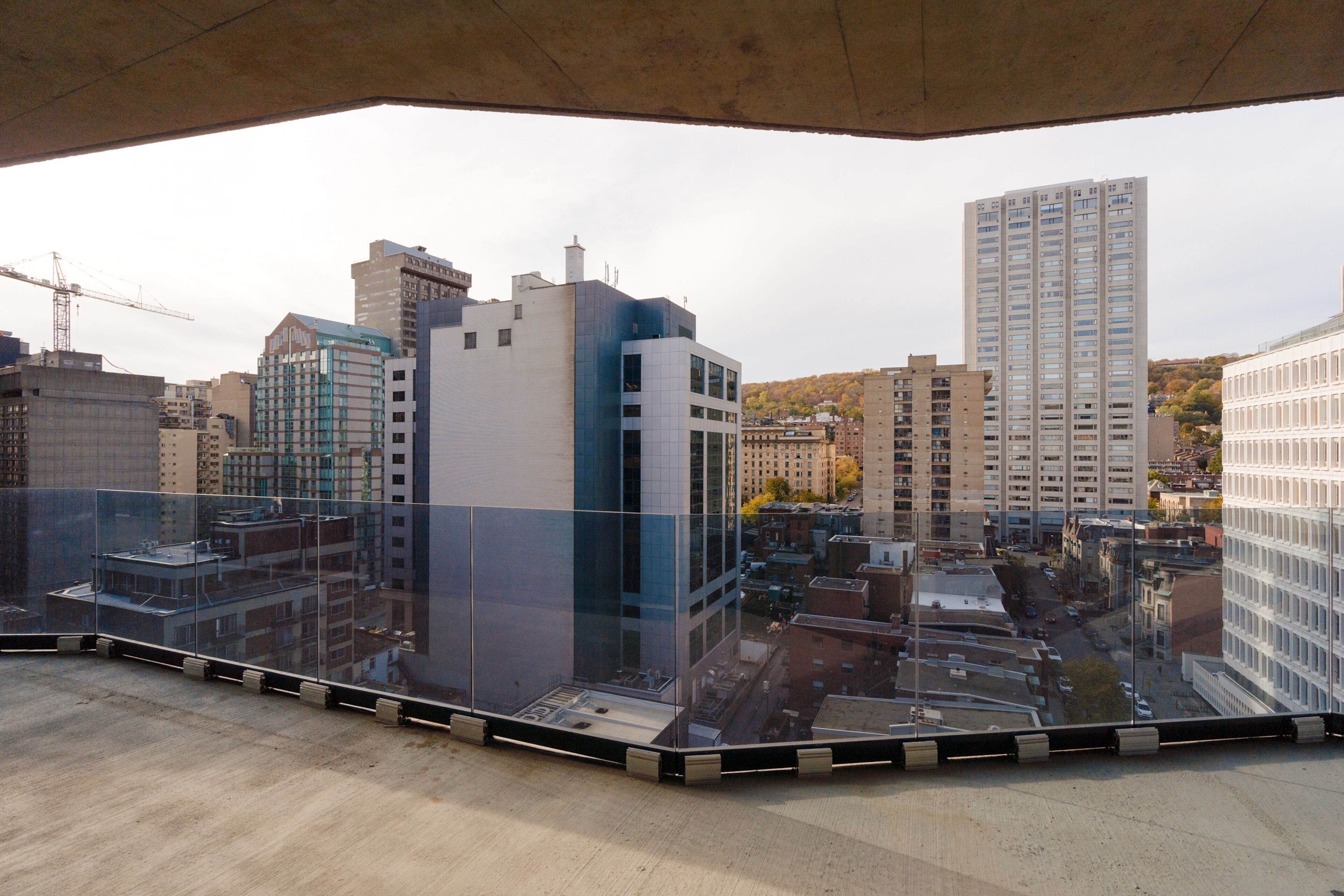 Un edificio alto con fachada de vidrio, varios pisos y vista panorámica de la ciudad.