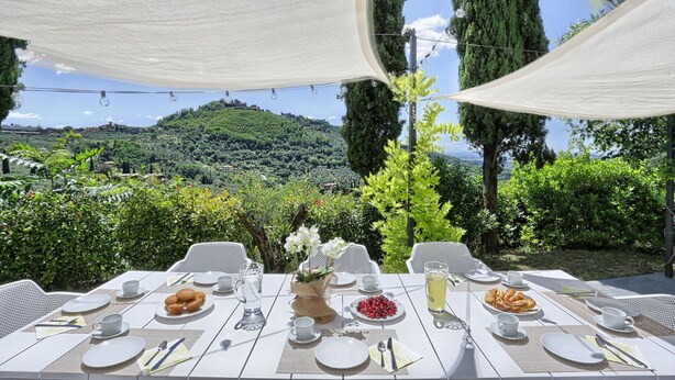 An outdoor dining area with tables set for a meal, overlooking a scenic hillside. - Wonderful private villa for 12 guests with private pool, WIFI, A/C (Montecatini Alto)