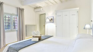 A hotel room with a bed, a radiator, a wardrobe, and a window with curtains. - Wonderful private villa for 12 guests with private pool, WIFI, A/C (Montecatini Alto)