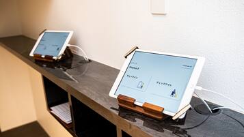Two tablet devices on a counter with a wooden stand, displaying a language learning application.