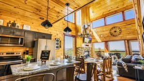 A spacious kitchen with granite countertops, stainless steel appliances, and a dining area with a large table and chairs. - Family-Friendly• Stunning Views • 7 Mi to Dollywood •Hot Tub• Highly Rated! (Sevierville)