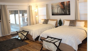 A hotel room with two beds, a large window with blinds, a painting on the wall, and a balcony with a door. - Indoor Pool , Hot Tub, Game Room & Gym  (South Jordan)