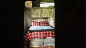 A narrow room with a wooden bed, a headboard, and a wooden floor. - Rustic Cabin on 7 Acres (Sparta)