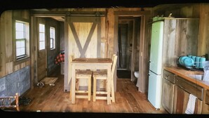 A rustic kitchen with wooden furniture, a green refrigerator, and a window. - Rustic Cabin on 7 Acres (Sparta)