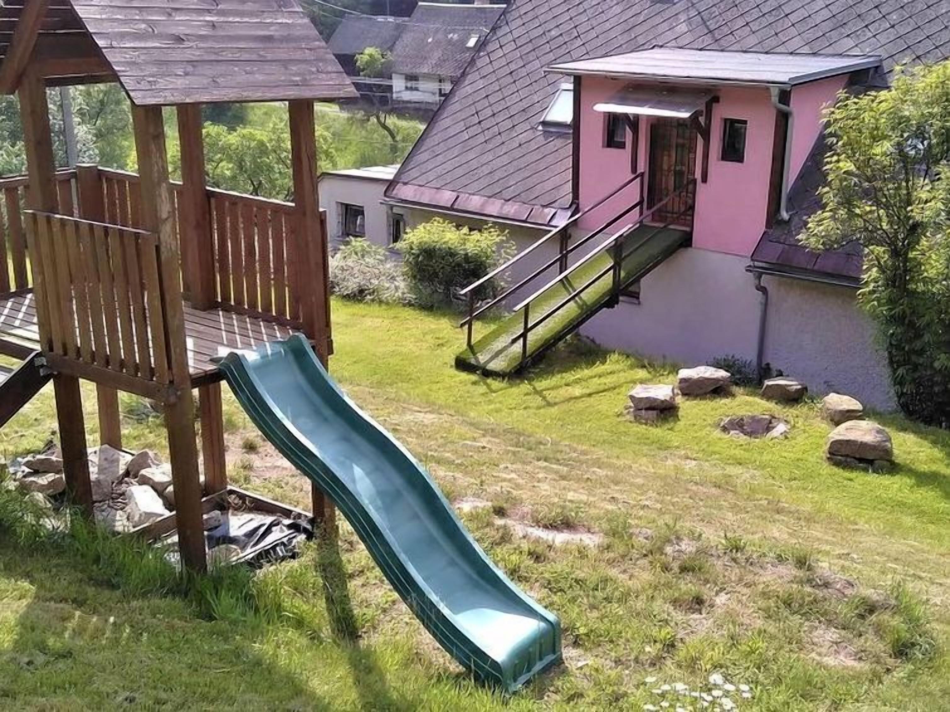 A playground with a slide and a wooden structure.