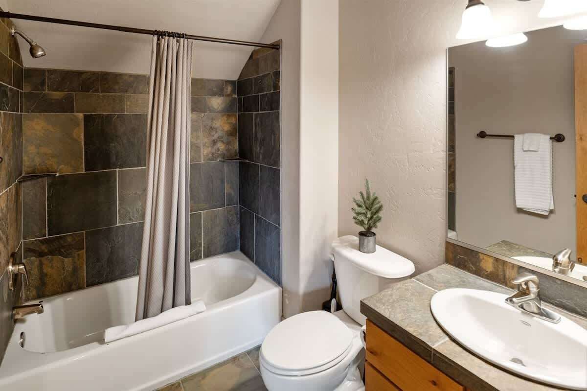 A bathroom with a bathtub, toilet, and sink.