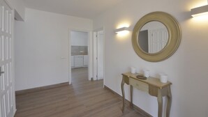 A hallway with a wooden floor, a console table with cups, and a round mirror on the wall. - To rent house with private pool in Begur, center (Begur)