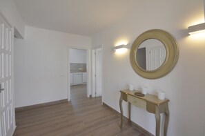 Enter a spacious room with a round mirror and a console table.