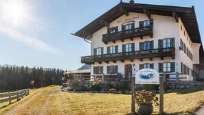 A traditional Alpine-style building with a balcony, a sign indicating it's a restaurant, and a path leading to it. - Holiday Apartment Guffertblick with Mountain View, Wi-Fi (Jachenau)