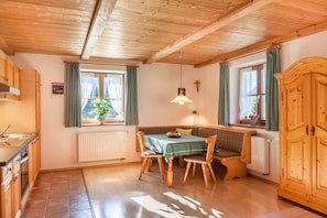 Un intérieur en bois comprenant une table à manger, des chaises, un banc, un radiateur et un meuble en bois.