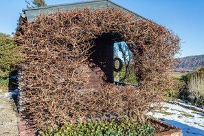 Un bâtiment partiellement recouvert de lierre, un mur de briques et une structure métallique.