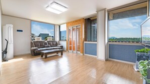 A spacious balcony with a wooden floor, a sofa, and a coffee table.