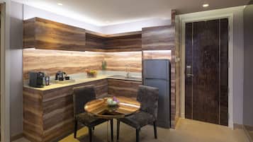 A modern kitchen with a built-in island, dark wood cabinetry, and a refrigerator.