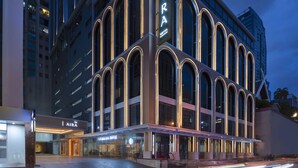 Un hotel moderno con ventanas arqueadas y un llamativo letrero 'AIRA'.