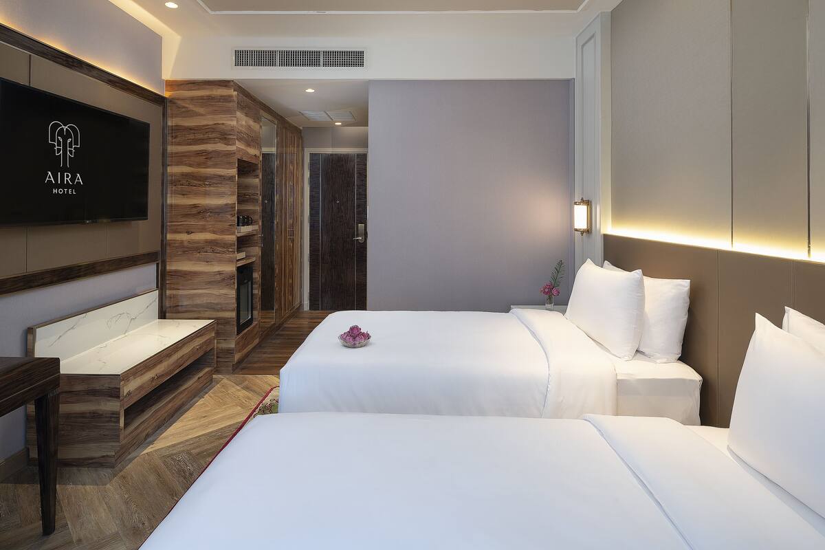 Una habitación de hotel con televisión, cama, escritorio y baño.
