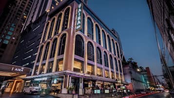 A multi-story building with a prominent 'AIRA' sign, featuring a Starbucks Coffee shop on the ground floor.