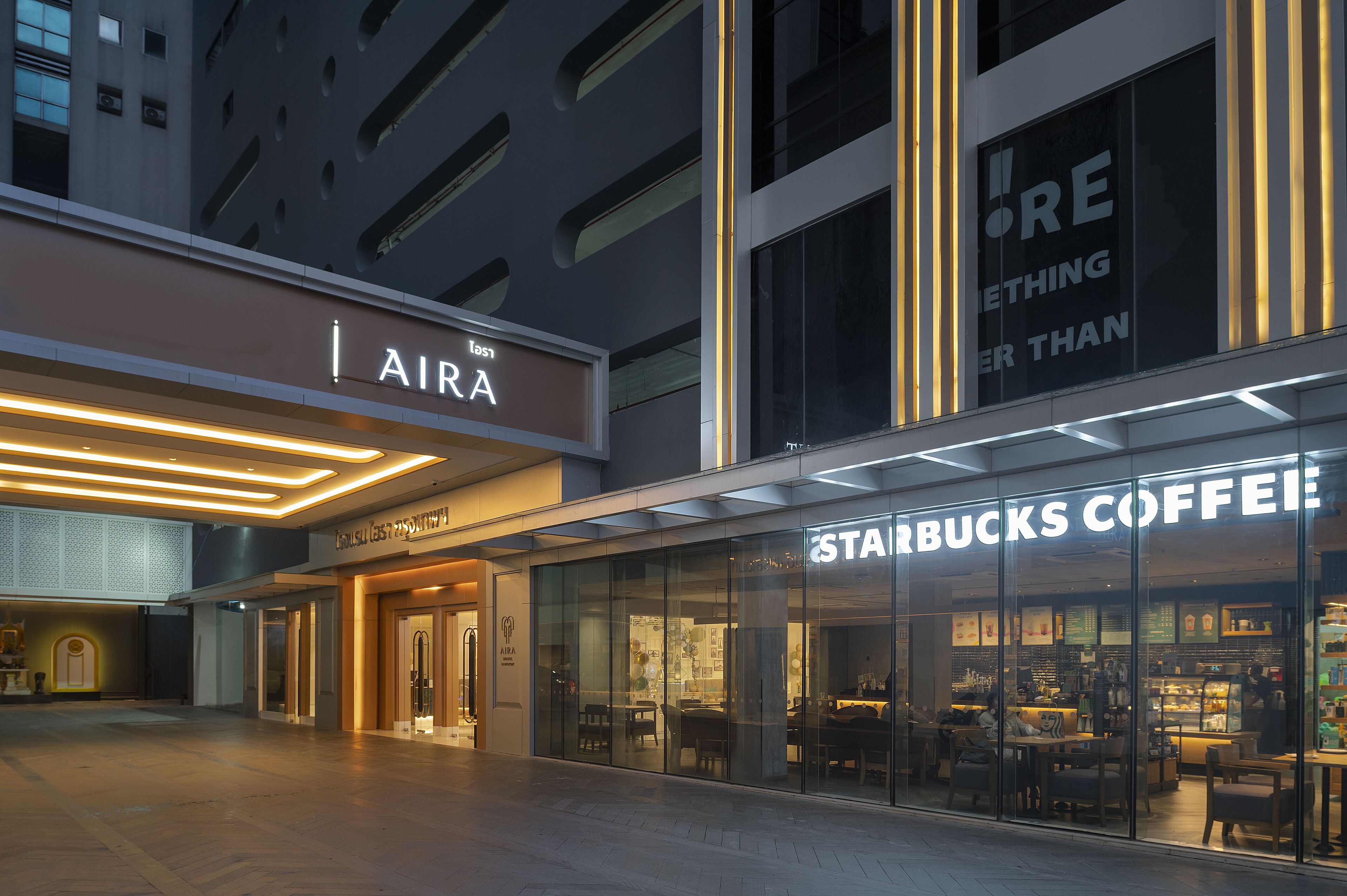 A modern building with a Starbucks Coffee store and an AIRA sign.