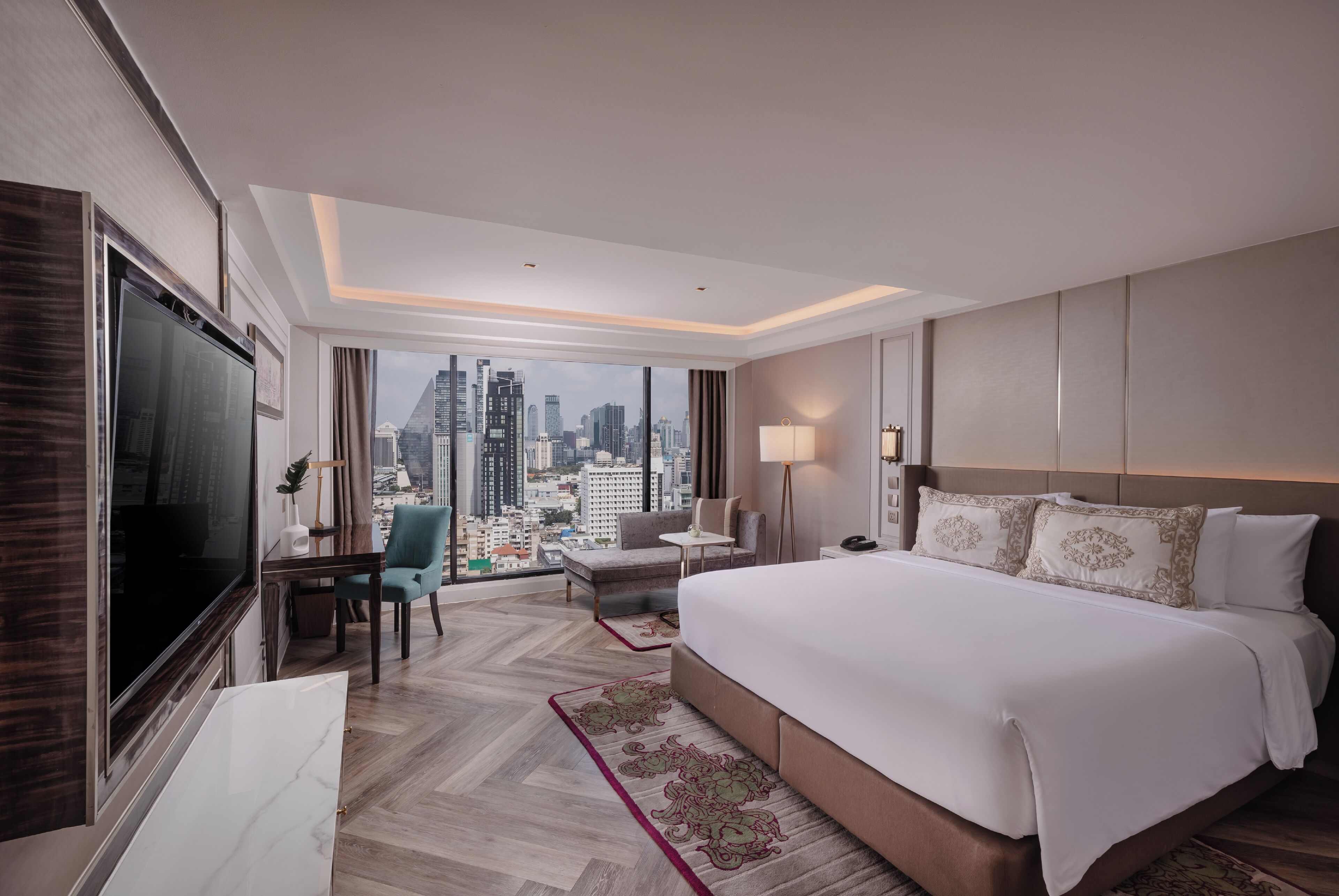 Une chambre d’hôtel avec un grand lit, un bureau, une chaise, une télévision et une vue sur le paysage urbain.