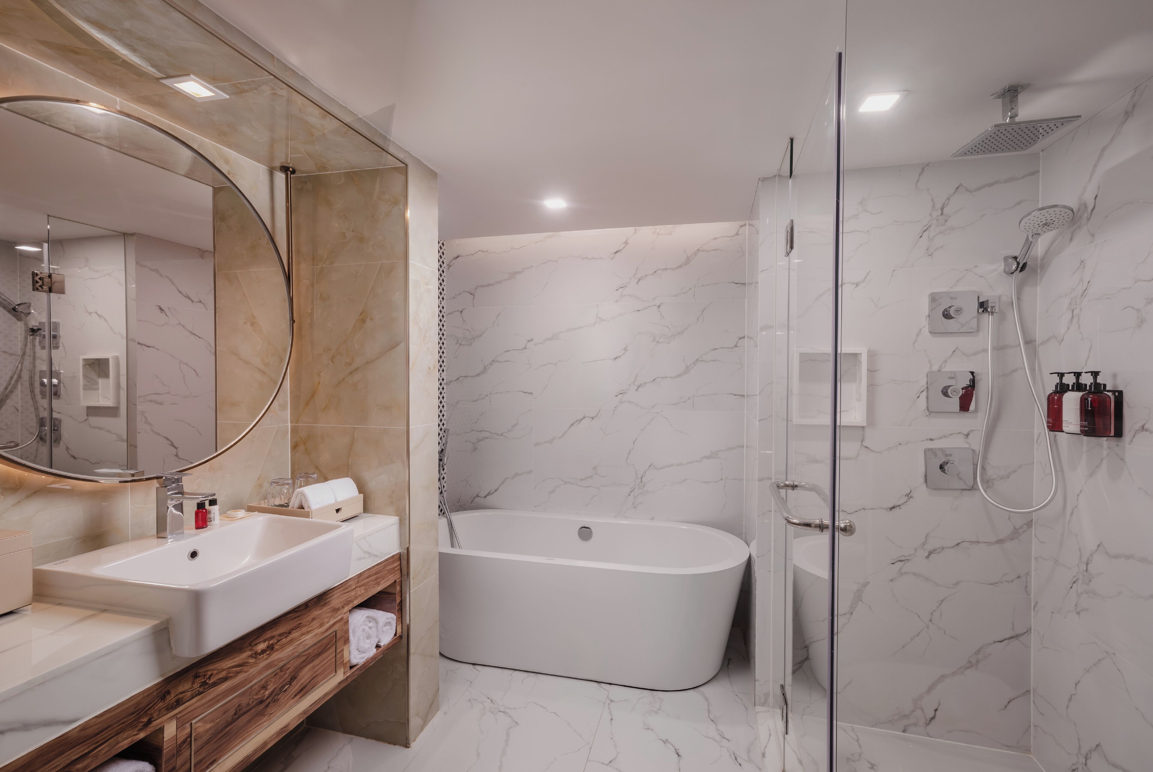 A modern bathroom with a freestanding bathtub, a large mirror, and a glass-enclosed shower area.