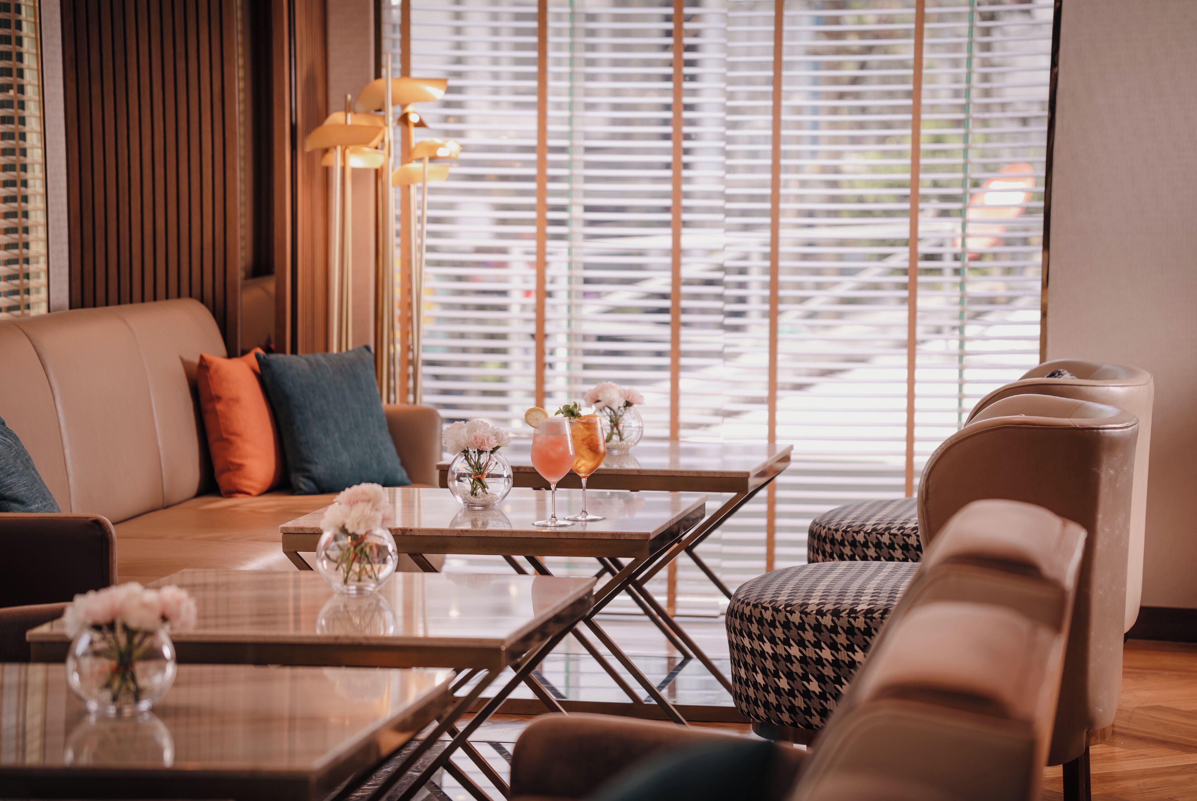 A modern living room with a sofa, armchairs, a coffee table, and a dining table.