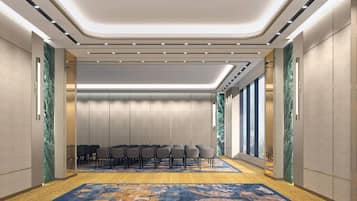 A conference room with a carpeted floor, a row of chairs, and a ceiling with recessed lighting.