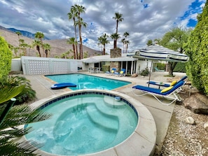 A pool area with a hot tub, lounge chairs, and a covered seating area. - NEW: Fun and Fabulous Renovation in Twin Palms (Palm Springs)