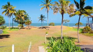 A golf course with palm trees and a view of the ocean. - Driftwood on the Beach - Sea View Unit 10 (Yeppoon)