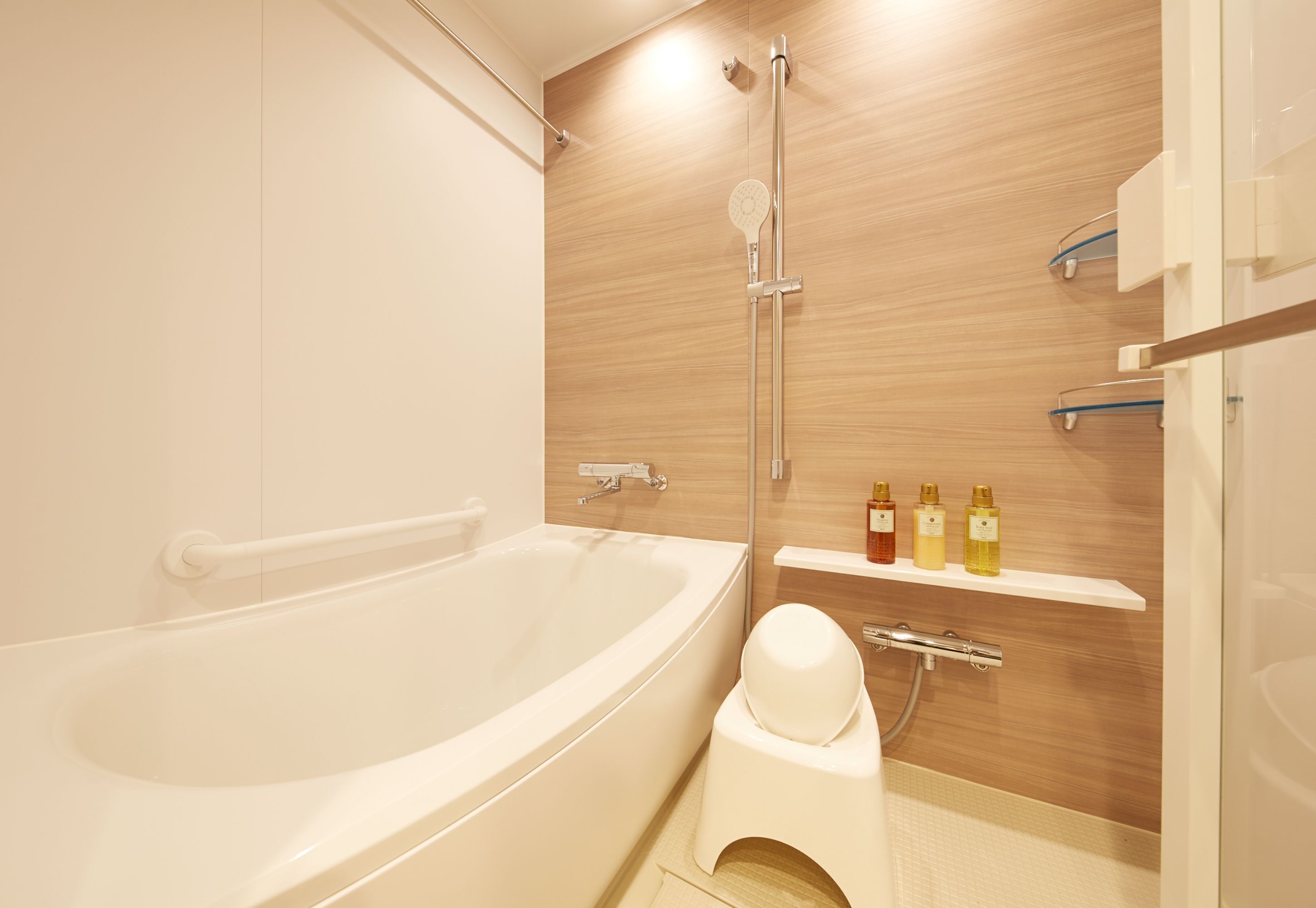 A modern bathroom with a freestanding bathtub, a showerhead, and a toilet.