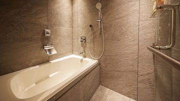A modern bathroom with a bathtub, shower, and a glass-enclosed medicine cabinet.