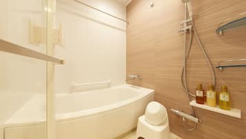 A modern bathroom with a freestanding bathtub, a showerhead, and a toilet.