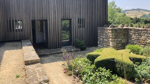 A modern building with vertical wooden panels and a stone wall.