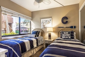 A bedroom with two beds, a window with a view, a wall-mounted letter 'C', and a decorative pillow with text. - Waterfront Views, Walk to Everything Pool, Pool (Sarasota)