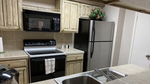 A kitchen with a stove, microwave, refrigerator, and sink. - Houston Med Center/NRG Area 2B/2B All Inclusive (Houston)