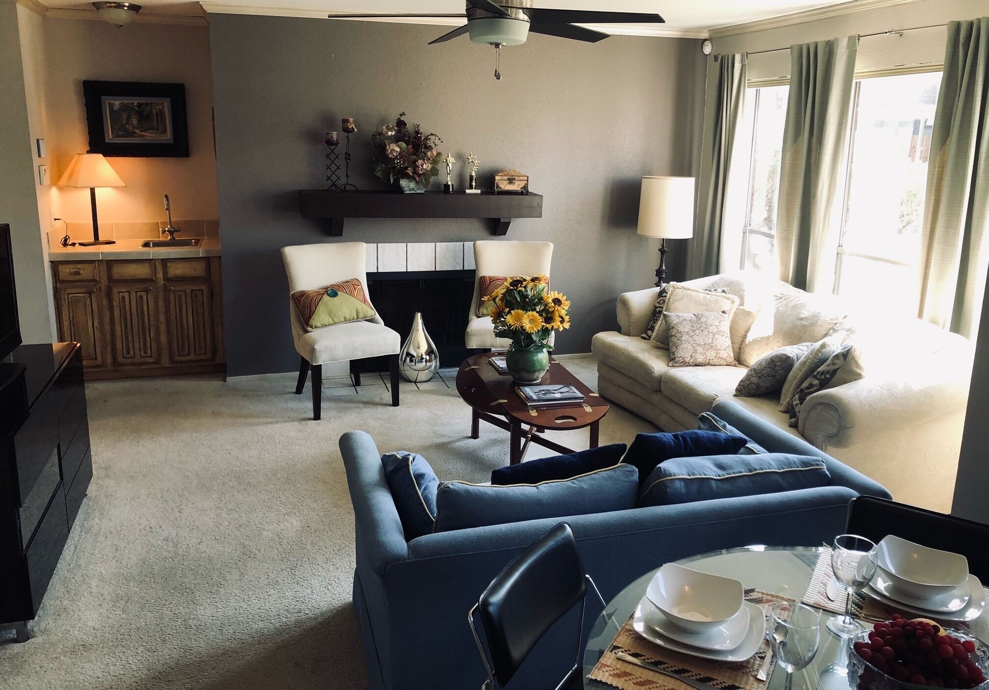 A living room with a sofa, armchairs, a coffee table, and a fireplace.