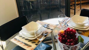 A dining area with a table set for two, including plates, glasses, cutlery, and a bowl of fruit. - Houston Med Center/NRG Area 2B/2B All Inclusive (Houston)