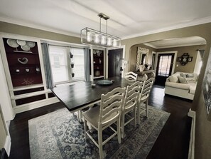 Enjoy meals in this dining area with a large window, dark wooden floor, and comfortable seating for six.